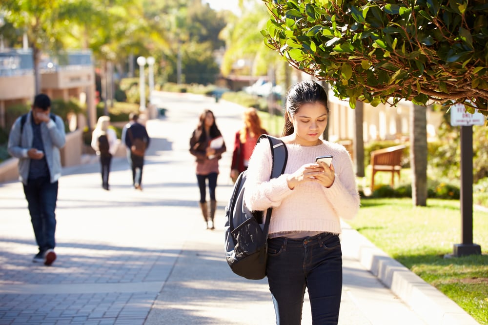 AtlasIED students walking outside on campus with female receiving notification on her phone AtlasIED students walking outside on campus with female receiving notification on her phone