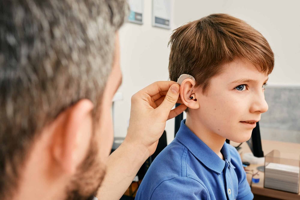 AtlasIED boy being fitted with hearing aid AtlasIED boy being fitted with hearing aid